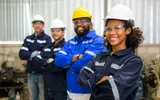 Group of confident technicians workers team standing at industrial factory