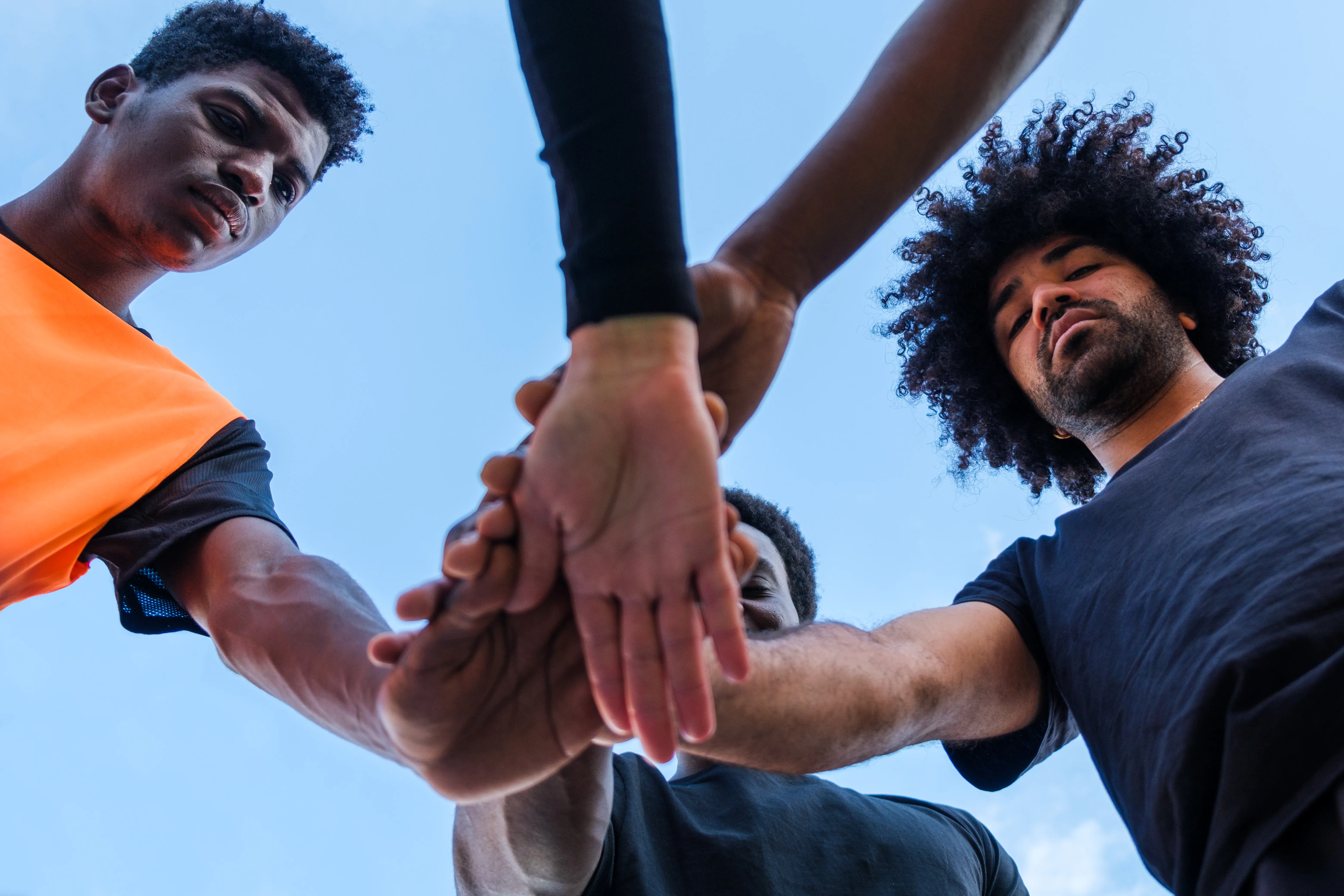 Team members joining hands together in a collaborative team building activity